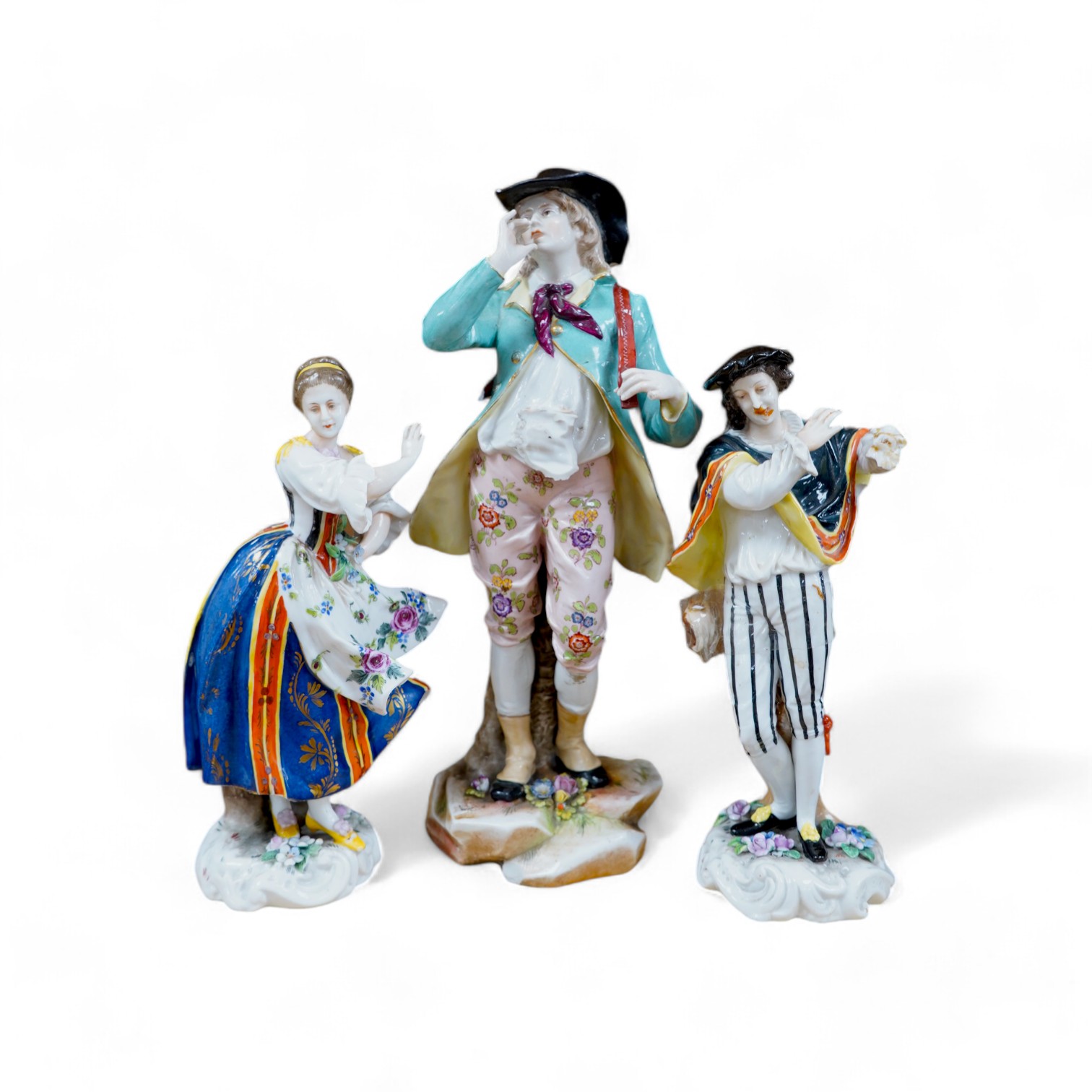 A Ludwigsburg porcelain figure and a pair of Berlin figures, tallest 27cm. Condition - poor